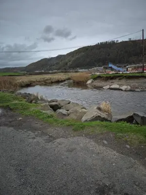 a river with rocks on the side of a road at The Dancing Dolphin, 124 Aber Bay Holiday Park, Clarach, Aberystwyth in Aberystwyth