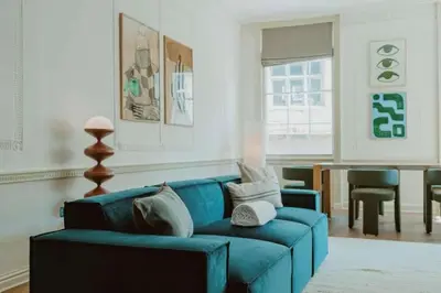 a living room with a blue couch and a table at The Catnap Suite in Shrewsbury