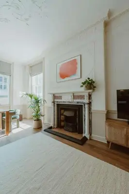 a living room with a fireplace and a tv at The Catnap Suite in Shrewsbury