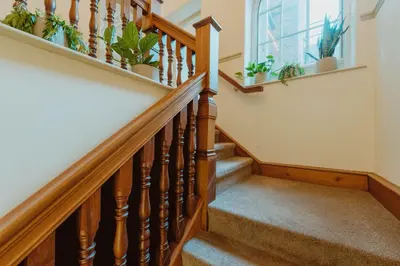 a staircase with wooden railings and potted plants at The Catnap Suite in Shrewsbury