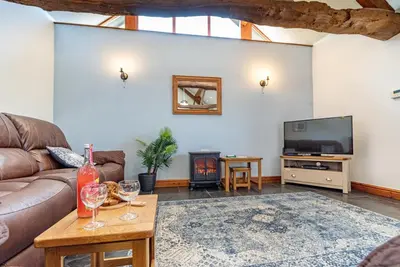 a living room with a couch and a tv at Beudy-Talsarnau in Talsarnau
