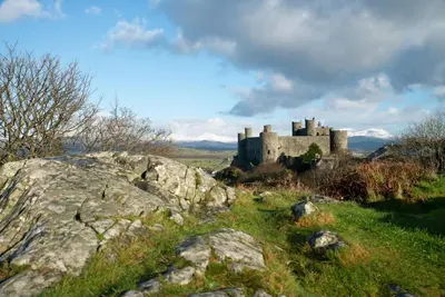 a castle on top of a hill with some rocks at Beudy-Talsarnau in Talsarnau