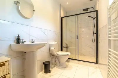 a bathroom with a toilet and a sink and a shower at Beudy-Talsarnau in Talsarnau