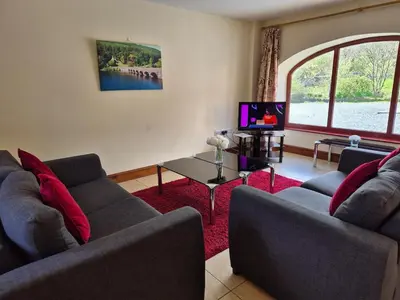 a living room with two couches and a tv at Hobby Stable Cottage in Cynghordy