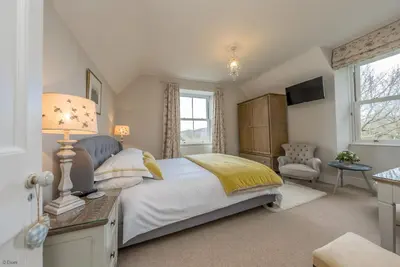 a bedroom with a bed and a table with a lamp at Cefn-Y-Maes in Dolgellau