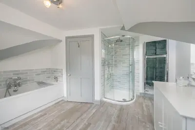 a white bathroom with a tub and a shower at Cefn-Y-Maes in Dolgellau