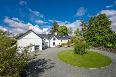 an exterior view of a white house with a driveway at Cefn-Y-Maes in Dolgellau