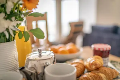a table topped with croissants and a bowl of bread at Hafan-Glan-Mor in Barmouth
