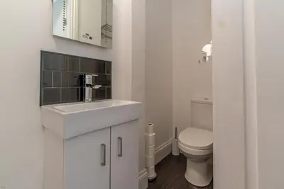 a white bathroom with a sink and a toilet at Hafan-Glan-Mor in Barmouth