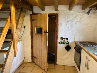 a kitchen with an open door in a room at The Old Barn in Bettws Gwerfil Goch