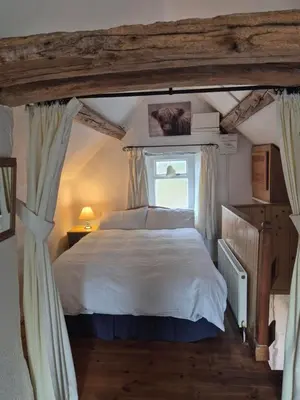 a bedroom with a large bed and a window at The Old Barn in Bettws Gwerfil Goch