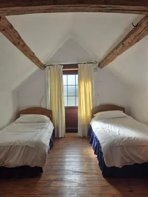 two beds in a room with a window at The Old Barn in Bettws Gwerfil Goch