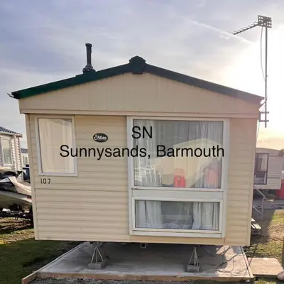 a small shed with the words sun sun sun sunsets and barnmut at Lyons Sunnysands - Sandy Cove 50 in Llanddwywe