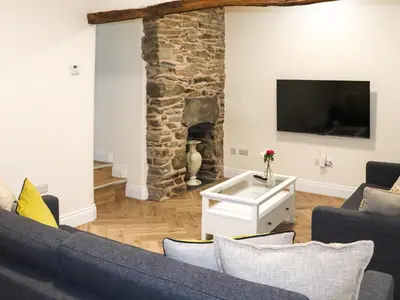 a living room with a blue couch and a stone fireplace at Apartment One - Uk49591 in Bala
