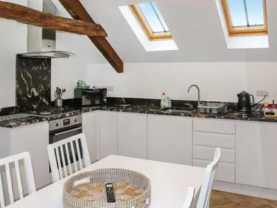 a kitchen with a white table and a kitchen with skylights at Apartment One - Uk49591 in Bala