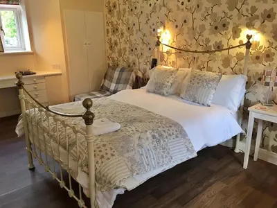 a bedroom with a bed and a chair at The Hand at Llanarmon in Llanarmon Dyffryn-Ceiriog