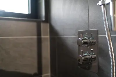 a close up of a bathroom wall with a metal switch at Y-Ddol in Dyffryn