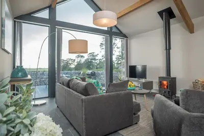 a living room with couches and a fireplace at Y-Ddol in Dyffryn