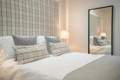 a bedroom with a white bed and a mirror at Y-Ddol in Dyffryn