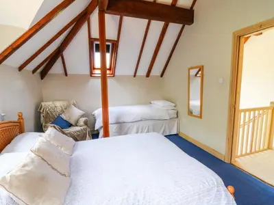 a bedroom with two beds and a window at Gaer Hall in Welshpool