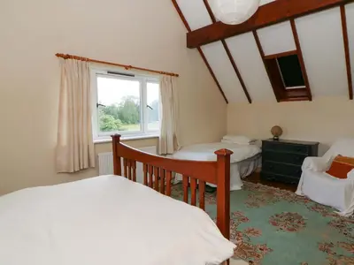 a bedroom with two beds and a window at Gaer Hall in Welshpool