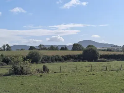a field of green grass with a fence in the foreground at Gaer Hall in Welshpool