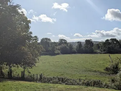 a large green field with a fence and trees at Gaer Hall in Welshpool