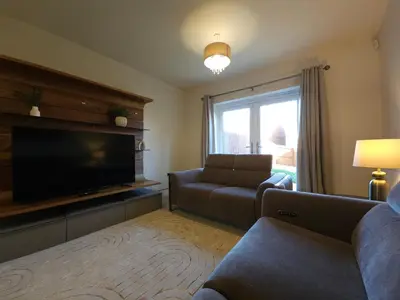 a living room with a couch and a flat screen tv at STYLISH & SPACIOUS 4 BEDROOM HOUSE - FREE DRIVEWAY PARKiNG in Shrewsbury