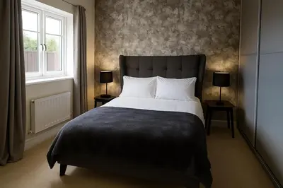 a bedroom with a large bed and a window at STYLISH & SPACIOUS 4 BEDROOM HOUSE - FREE DRIVEWAY PARKiNG in Shrewsbury