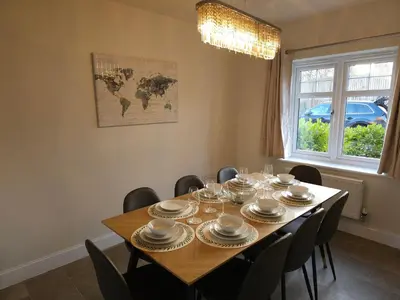 a dining room with a table with chairs and a world map at STYLISH & SPACIOUS 4 BEDROOM HOUSE - FREE DRIVEWAY PARKiNG in Shrewsbury