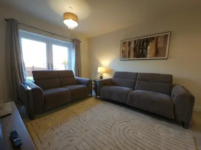 a living room with a couch and a chair at STYLISH & SPACIOUS 4 BEDROOM HOUSE - FREE DRIVEWAY PARKiNG in Shrewsbury