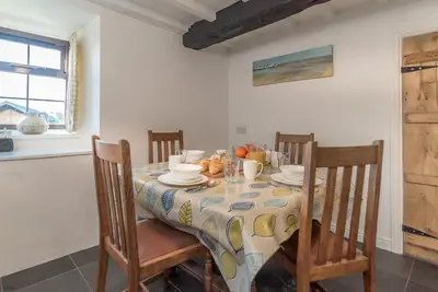 a dining room table with chairs and a tablecloth on it at Y-Felin in Dyffryn