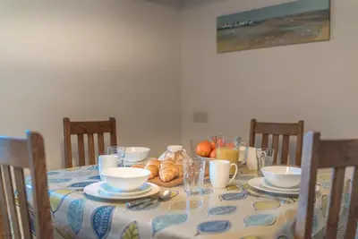a dining room table with a table cloth with bowls and cups at Y-Felin in Dyffryn