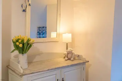 a teddy bear sitting on a counter in a bathroom with a mirror at Y-Felin in Dyffryn