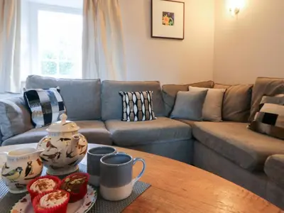 a living room with a couch and a table at Secret Garden Cottage in Lampeter
