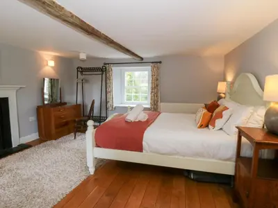 a bedroom with a bed and a window at Secret Garden Cottage in Lampeter