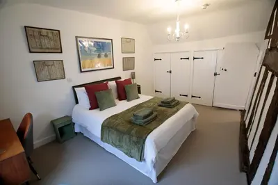 a bedroom with a large white bed with red pillows at Pepper House Rooms - shared facilities - pet friendly in Ludlow