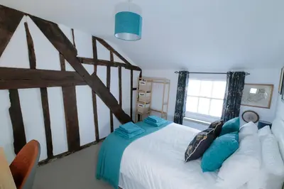 a bedroom with a large white bed with blue pillows at Pepper House Rooms - shared facilities - pet friendly in Ludlow