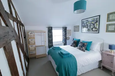 a bedroom with a bed with blue pillows at Pepper House Rooms - shared facilities - pet friendly in Ludlow