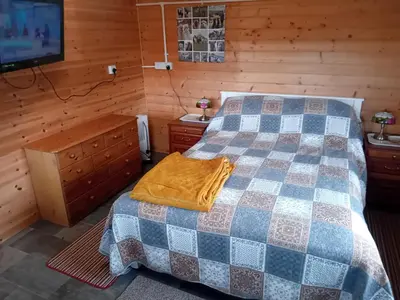 a bedroom with a bed and a tv on a wall at Alpaca Hideaway in Newtown