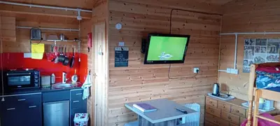 a room with a television on a wall with a table at Alpaca Hideaway in Newtown