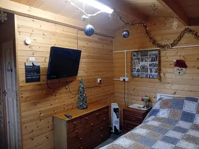 a bedroom with a bed and a flat screen tv at Alpaca Hideaway in Newtown