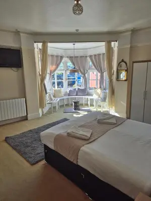 a bedroom with a large bed and a large window at The Stokesay Inn in Craven Arms