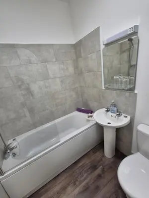 a bathroom with a tub and a sink and a toilet at The Stokesay Inn in Craven Arms
