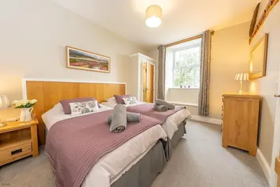a bedroom with a large bed and a window at Faeldre in Dyffryn