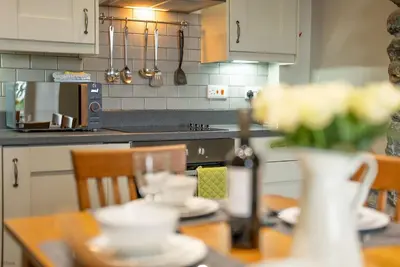 a kitchen with a table with dishes on it at Faeldre in Dyffryn