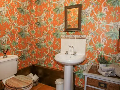 an orange bathroom with a sink and a toilet at Upper Home Farm in Church Stretton