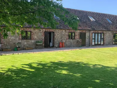 a brick house with a large lawn in front of it at Upper Home Farm in Church Stretton