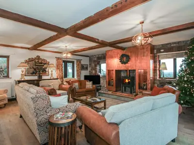 a living room with couches and a christmas tree at Upper Home Farm in Church Stretton