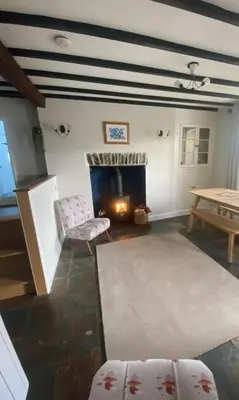 a living room with a fireplace and a table at Manteg in Aber-Arth